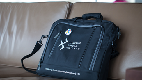 A black laptop bag on a brown sofa.