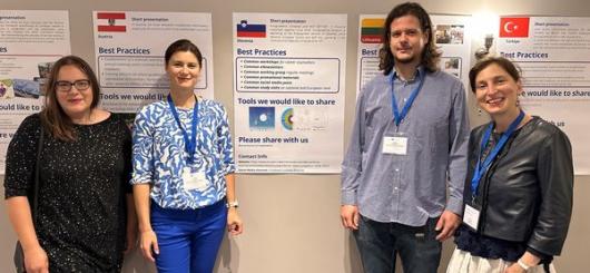 Fotografija predstavnikov SOK, EG in Europass Slovenija pred skupnim plakatom sodelovanja treh mrež